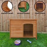 Mittelgroße Hundehütte aus Holz mit Dachöffnung, Bodenfreiheit und Türklappen, umgeben von grünem Gras und einem Holzzaun im Hintergrund