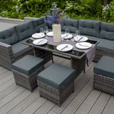 Elegantes Polyrattan Gartenmöbel Set in Grau mit bequemen Kissen, einem Tisch mit Glasplatte und stilvollen Hockern, umgeben von grüner Natur