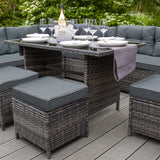 Elegantes Polyrattan Gartenmöbel Set in Grau mit bequemen, gepolsterten Sitzkissen, stilvollem Tisch und dekorativen Gläsern auf einer Holzterrasse