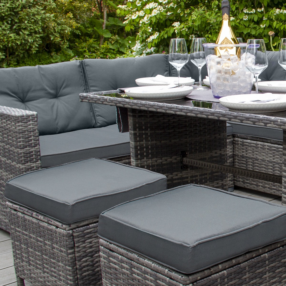 Elegantes Polyrattan Gartenmöbel Set in Grau mit bequemen Sitzkissen, stilvollem Tisch und Gläsern auf einem modernen Terrassenboden