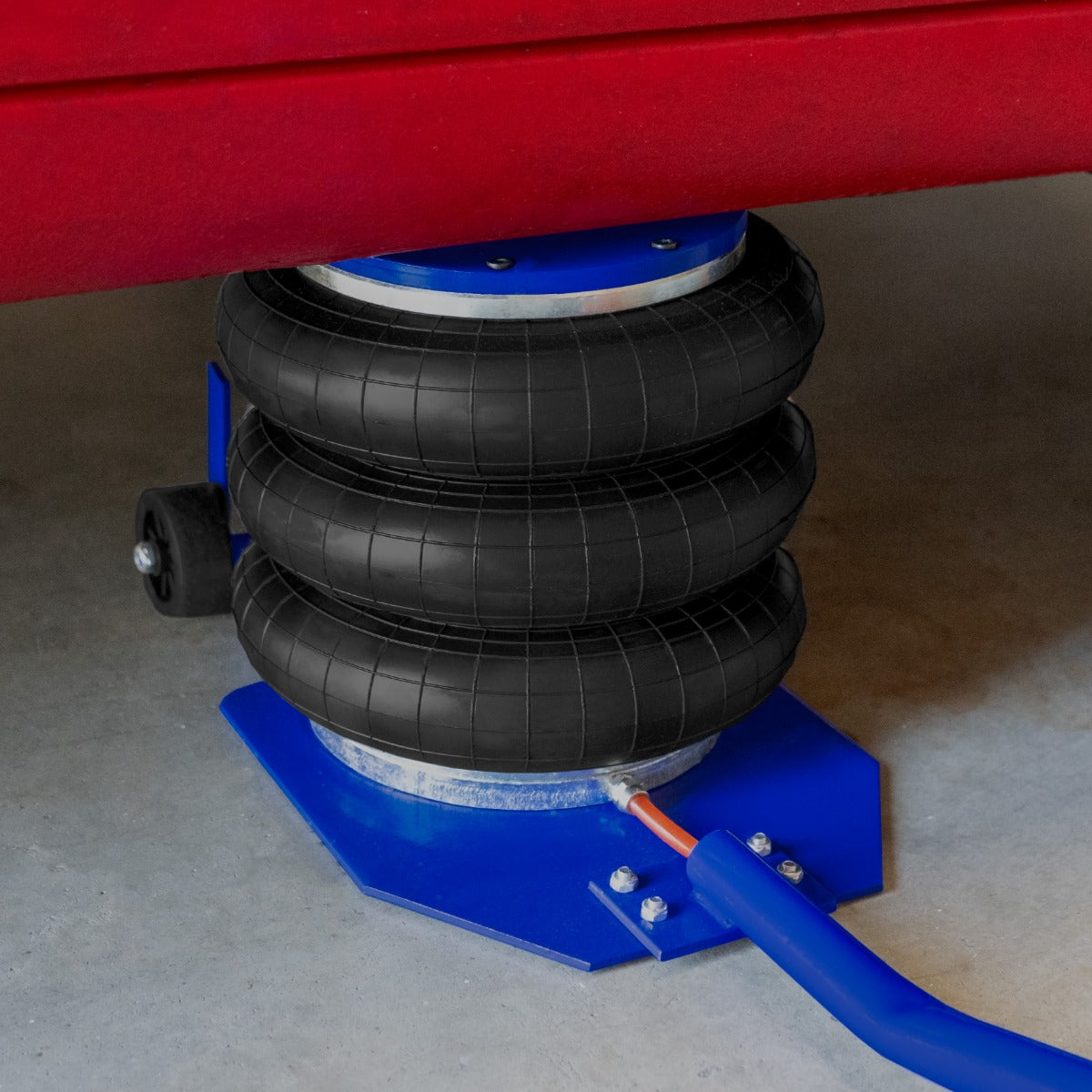 Pneumatischer Wagenheber in Blau mit drei schwarzen Gummibälgen, stabil auf einer grauen Betonoberfläche, ideal für Fahrzeuganhebungen