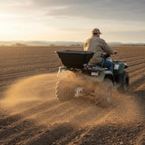 ATV-Streuer für Quad, der Dünger gleichmäßig auf ein braunes Feld verteilt, während ein Fahrer in beiger Jacke und Kappe fährt
