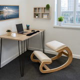 Ergonomischer Kniestuhl aus hellem Holz mit bequemen, hellen Polstern, platziert in einem modernen Büro mit Schreibtisch und Pflanzen