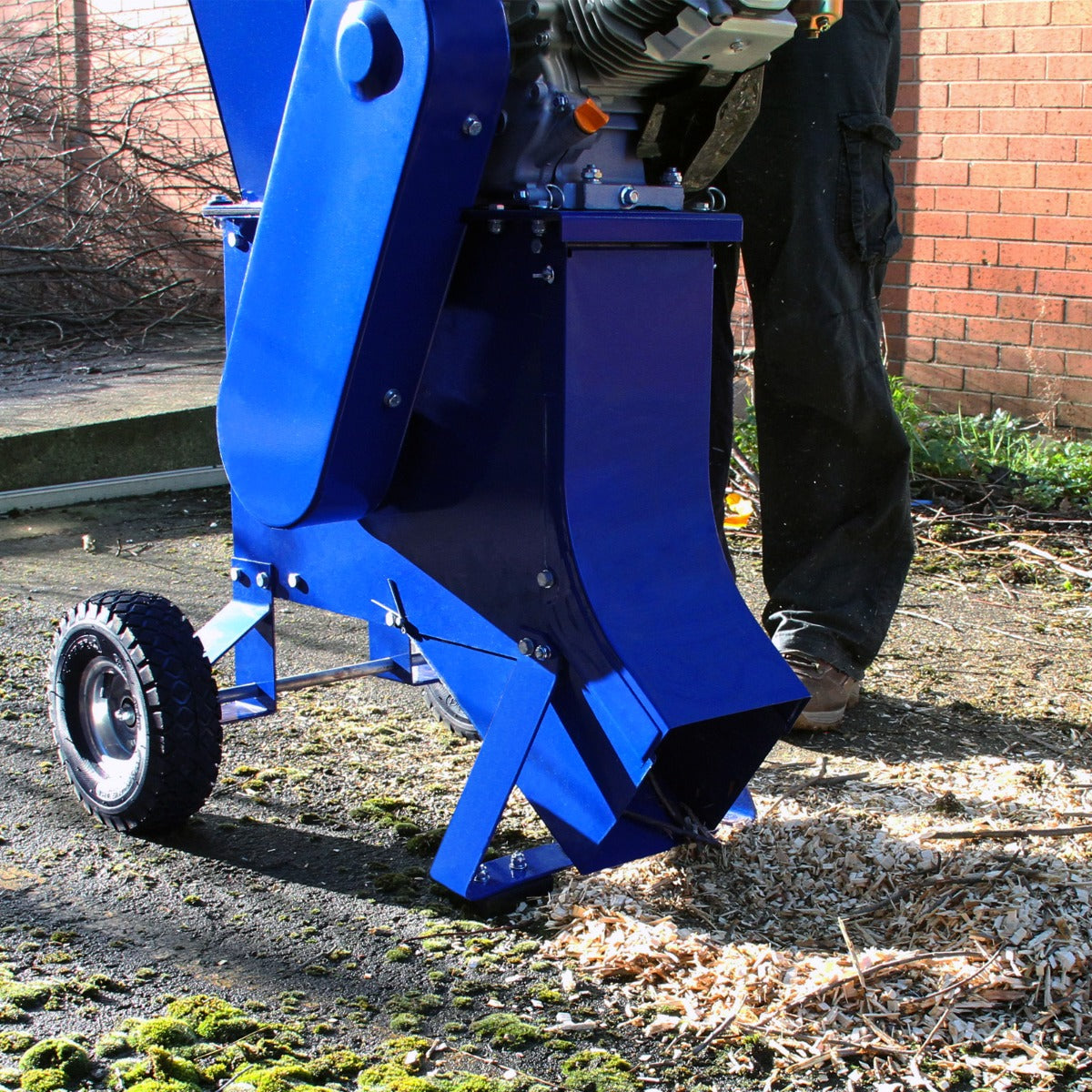 Der T-Mech 7PS Holzhäcksler in leuchtendem Blau mit robustem Metallgehäuse und großen Rädern, ideal zum Zerkleinern von Holzabfällen auf unebenem Boden