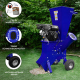 Blauer T-Mech 7PS Holzhäcksler mit robustem Motor, 76 mm Schneidekapazität und großen, stabilen Rädern auf grünem Rasen, umgeben von Pflanzen