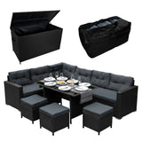 Schwarze Rattan Eckgarnitur mit bequemen, grauen Kissen, dazu eine praktische Kissenbox und ein eleganter Tisch, ideal für den Außenbereich