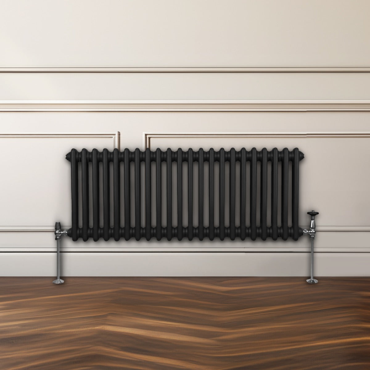 Traditioneller 2-Spalten-Heizkörper in Schwarz, 300 x 1012 mm, mit glänzenden Metallfüßen, vor einer hellen Wand und einem Holzfußboden