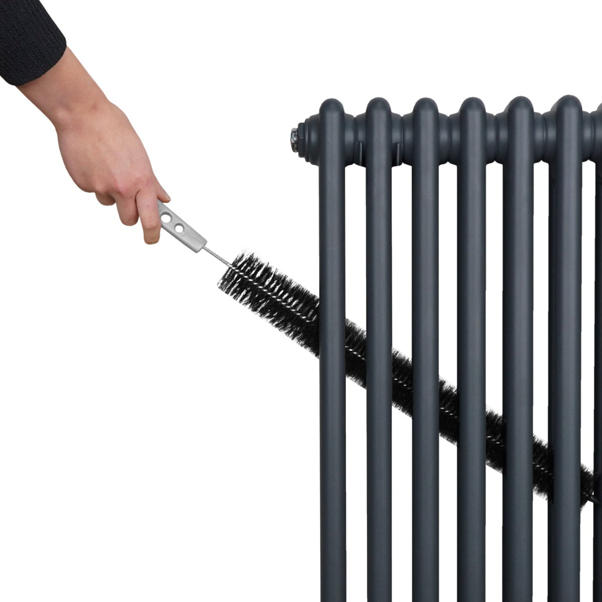 Anthrazitgrauer 2-Spalten-Heizkörper mit glänzender Oberfläche, während eine Hand mit einer Bürste die Lamellen reinigt