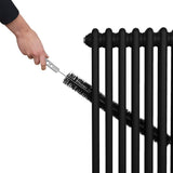 Schwarzer, traditioneller 2-Spalten-Heizkörper mit 1800 x 292 mm, während eine Hand mit einer Bürste die Lamellen reinigt
