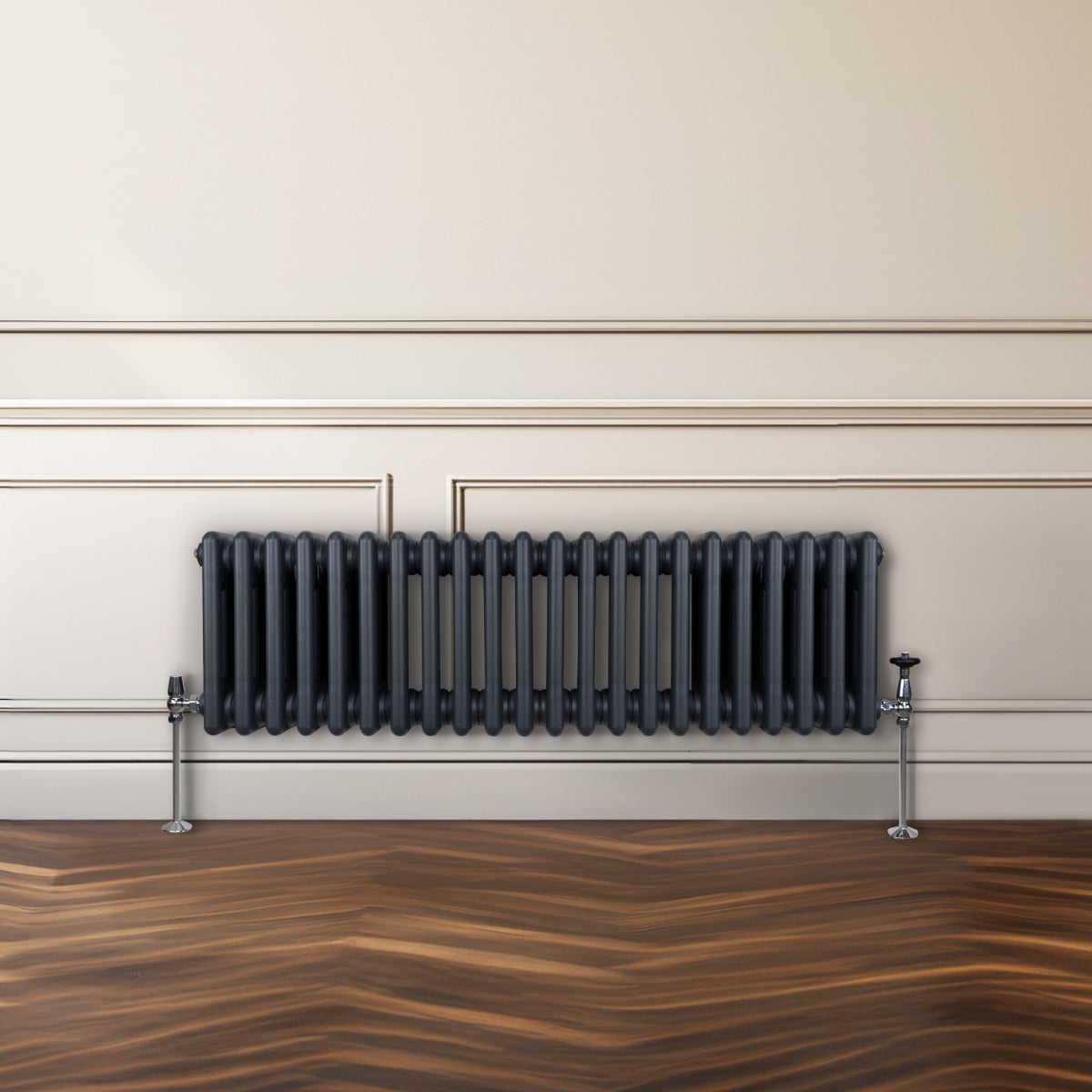 Traditioneller 3-Spalten-Heizkörper in Anthrazitgrau, mit glatten, vertikalen Lamellen und glänzenden Metallfüßen, vor einer hellen Wand platziert