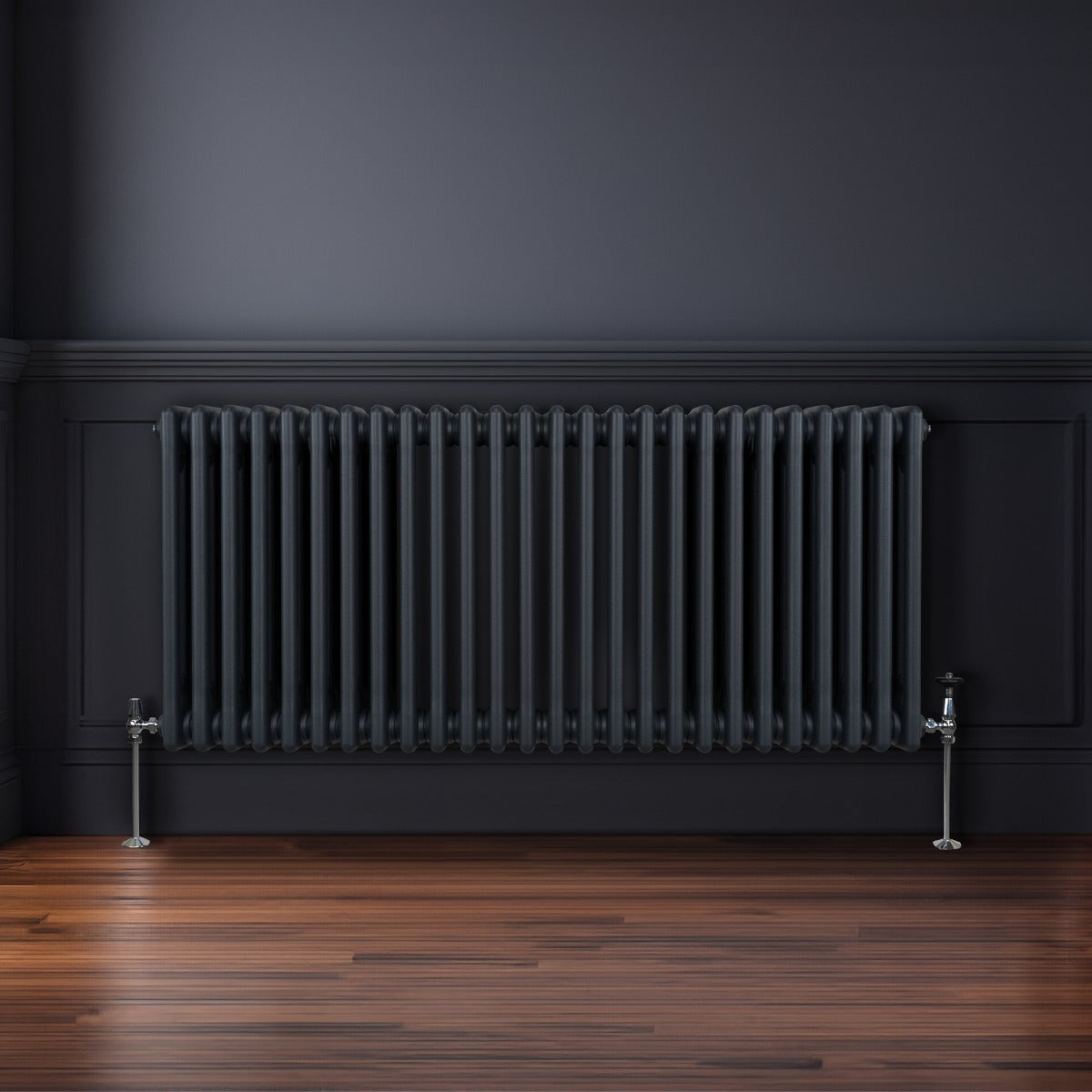 Traditioneller 3-Spalten-Heizkörper in Anthrazitgrau, 600 x 1192 mm, mit glänzenden Metallfüßen und vertikalen Lamellen, vor einer dunklen Wand