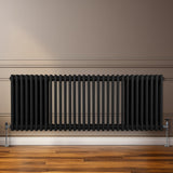 Traditioneller 3-Spalten-Heizkörper in Schwarz, 600 x 1462 mm, mit glatten, vertikalen Lamellen und stabilen Füßen, ideal für moderne Innenräume