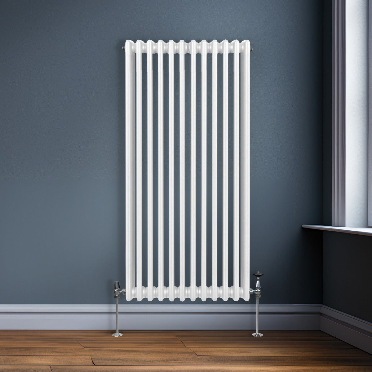 Traditioneller 3-Spalten-Heizkörper in Weiß, 1500 x 562 mm, mit glatten, vertikalen Lamellen und eleganten, verchromten Ventilen, vor grauer Wand
