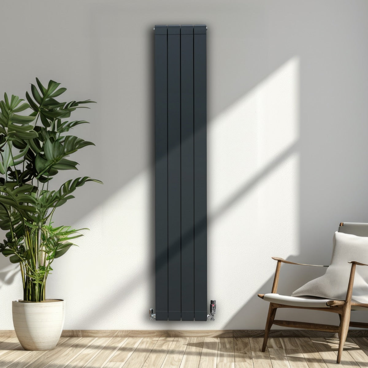 Anthrazitgrauer Aluminium Paneelheizkörper mit schlankem Design, 1800mm x 315mm, montiert an einer hellen Wand, umgeben von Pflanzen und einem Stuhl