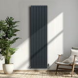Anthrazitgrauer Aluminium Paneelheizkörper mit vertikalen Lamellen, 1800mm x 475mm, elegant an einer hellen Wand, umgeben von Pflanzen und einem Stuhl