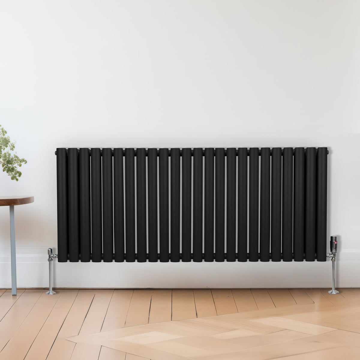 Schwarzer Heizkörper mit vertikalen Lamellen, elegant und modern, ideal für zeitgemäße Innenräume, ergänzt durch Chrom-Thermostatventile