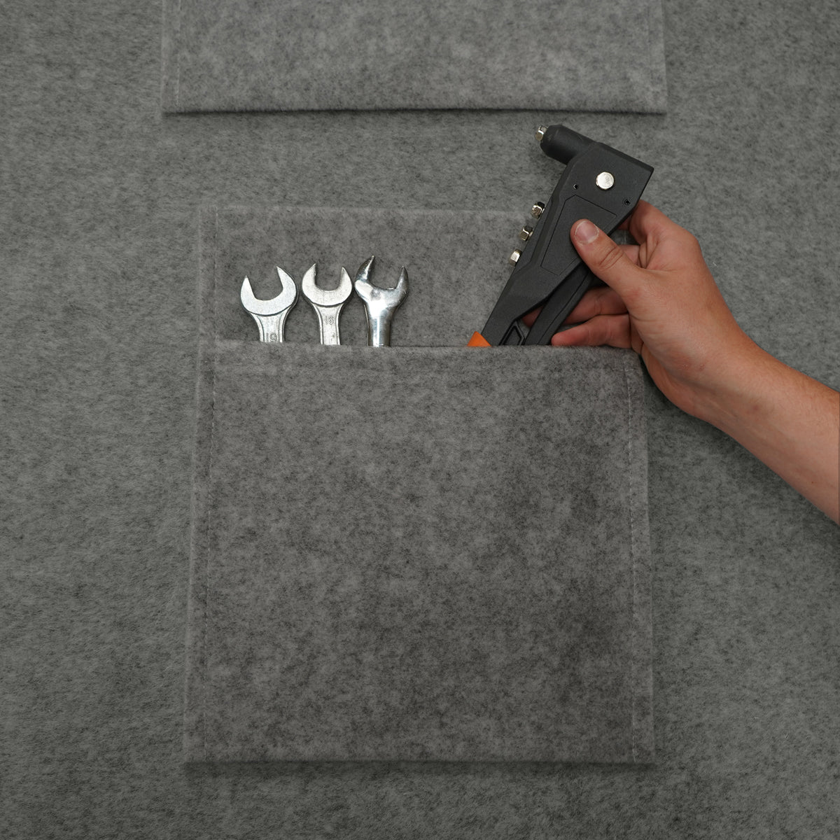 Rauchgraue Autostoff-Aufbewahrungstaschen mit Werkzeugen, handgehaltene Klebepistole, weiche Textur und praktische Fächer für Ordnung