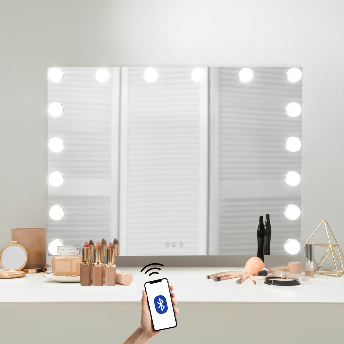 LED Bluetooth Spiegel in rechteckiger Form, 80 x 60 cm, mit 12 leuchtenden Glühbirnen, auf einem Schminktisch mit Kosmetikprodukten und Smartphone platziert