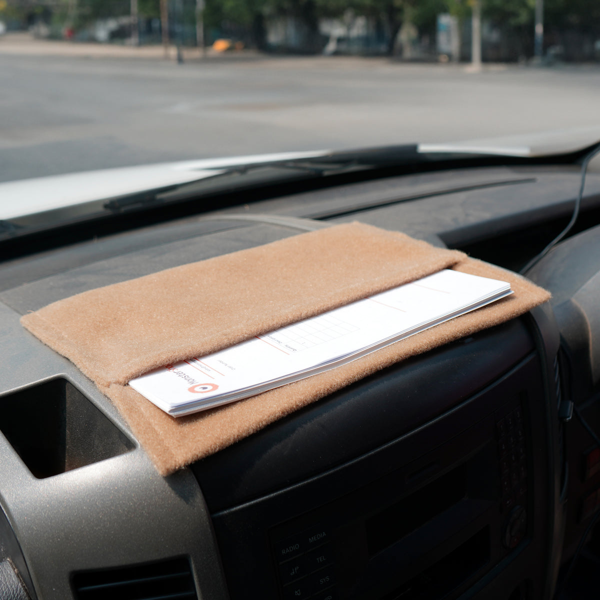 Beige Aufbewahrungstaschen aus weichem Material, ideal für die Organisation von Dokumenten, auf einem Armaturenbrett platziert
