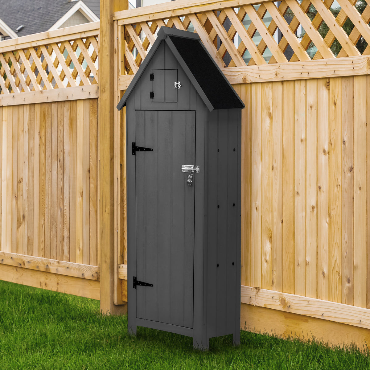 Grau lackierter Gartenschrank aus Holz mit schrägem Dach, stabilen Türen und metallischen Beschlägen, steht auf grünem Rasen neben einem Holzzaun