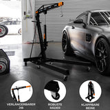 Schwarzer Werkstattkran mit orangefarbenen Akzenten, klappbaren Beinen und robusten Rädern, ideal für das Heben von Motoren bis 2 Tonnen