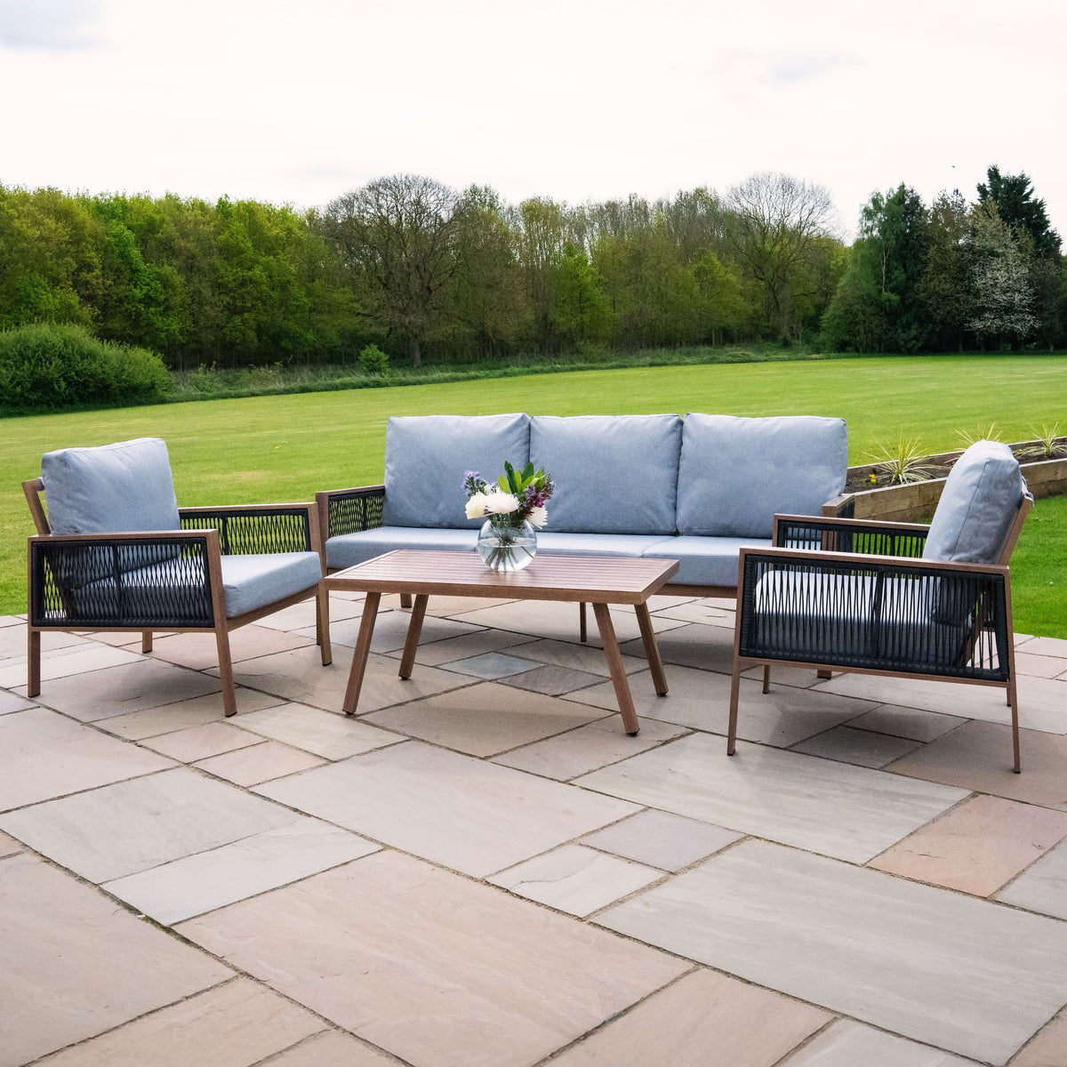 Elegante 4-teilige Aluminium-Sofagarnitur mit Holzdetails, grauen Kissen und einem modernen Tisch, ideal für den Außenbereich auf einer Terrasse