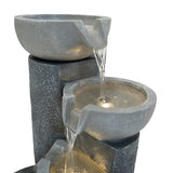 Elegante elektrische Wasseranlage "Tranquil Tiers" mit grauen, schalenförmigen Behältern, die sanft Wasser über glatte Steine fließen lassen