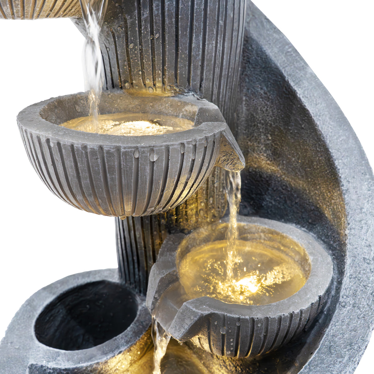 Elegante elektrische Wasseranlage "Spiral Springs" mit drei runden Schalen, die sanft Wasser abgeben, in dunklem Steinoptik und warmem Licht