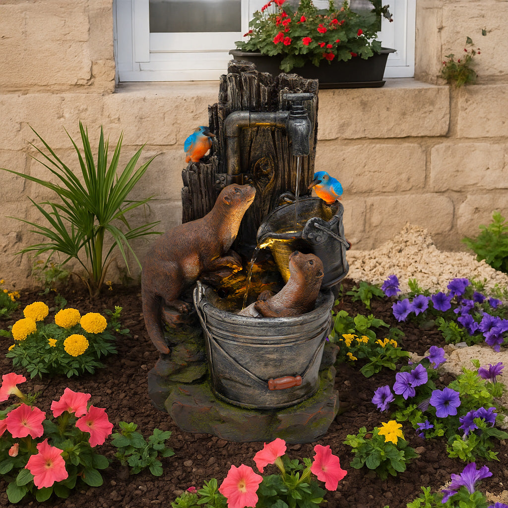 Zwei Otter spielen in einer Wasseranlage mit rustikalem Design, umgeben von bunten Blumen und einer grünen Pflanze, die lebendige Farben und Texturen bieten