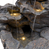 Rustikale Wasseranlage mit mehreren Ebenen aus grauem Stein, sanft fließendem Wasser und integrierten LED-Lichtern, die eine entspannende Atmosphäre schaffen
