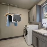 Schwarzfarbener 6-Latten-Wäscheständer mit Deckenrollen, an der Decke hängend, mit verschiedenen Kleidungsstücken in einem modernen, hellen Waschraum