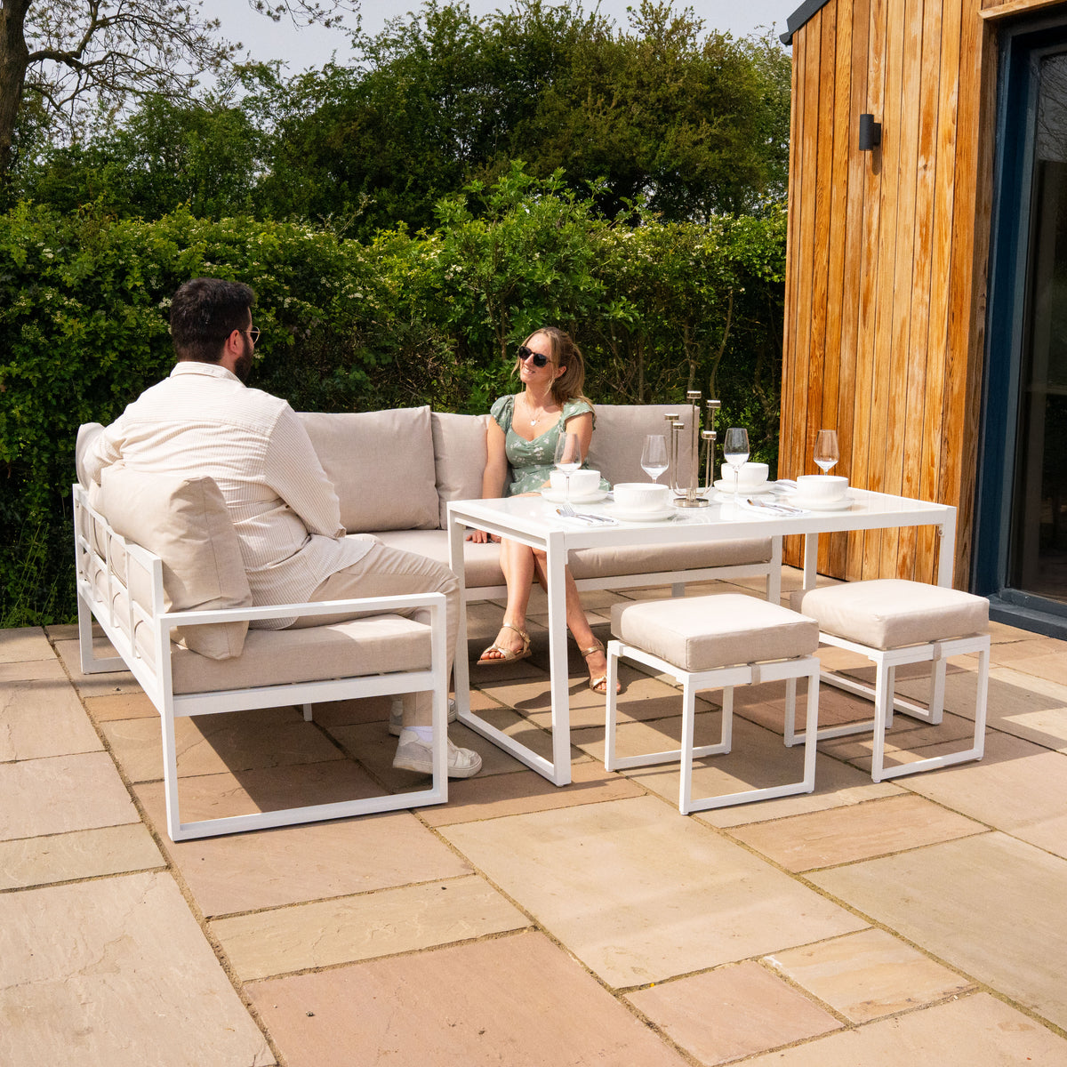Elegantes 5-teiliges Ecksofa-Set aus Aluminium in Weiß, mit bequemen Kissen, ideal für den Außenbereich, umgeben von grüner Natur und Holzverkleidung