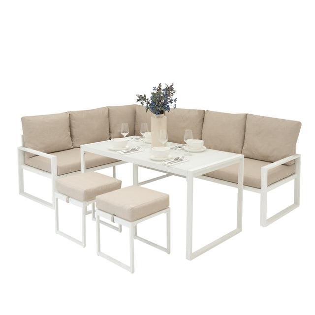Elegantes 5-teiliges Ecksofa-Set in Weiß mit beigen Kissen, ergänzt durch eine schwarze Rattan-Aufbewahrungsbox und stilvolles Tischgedeck
