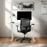 Moderner elektrischer Stehschreibtisch in Weiß mit Schublade, 120 cm x 60 cm, kombiniert mit einem ergonomischen Bürostuhl und stilvollen Wandbildern