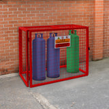 Robuster, zusammenklappbarer Gasflaschenschrank in leuchtendem Rot, mit drei Gasflaschen in Blau und Grün, sicher eingezäunt und beschildert
