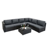 Schwarzes Rattan-Möbelset mit modularen Elementen, gepolsterten grauen Kissen und einem eleganten Glastisch, ideal für den Außenbereich