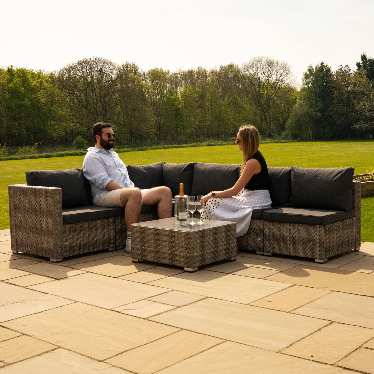 Modulares 7-teiliges Rattan-Möbelset in Grau, bestehend aus bequemen Sofas und einem Tisch, ideal für den Außenbereich, mit eleganten Kissen und natürlichem Look