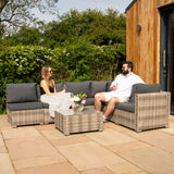 Modulares 7-teiliges Rattan-Möbelset in Grau, bestehend aus bequemen Sofas und einem eleganten Glastisch, ideal für entspannte Outdoor-Zeiten