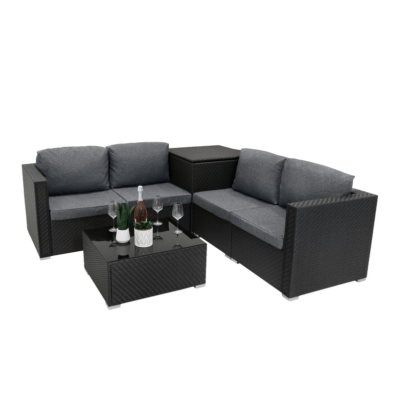 Modular Gartenlounge aus schwarzem Rattan mit grauen Kissen, inklusive einem eleganten Tisch, ideal für entspannte Sommerabende