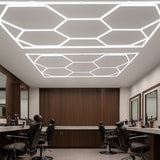 Sechseckige LED-Leuchten in modernem Design, strahlend weiß, an der Decke montiert, umgeben von eleganten Friseurstühlen und Holzverkleidung
