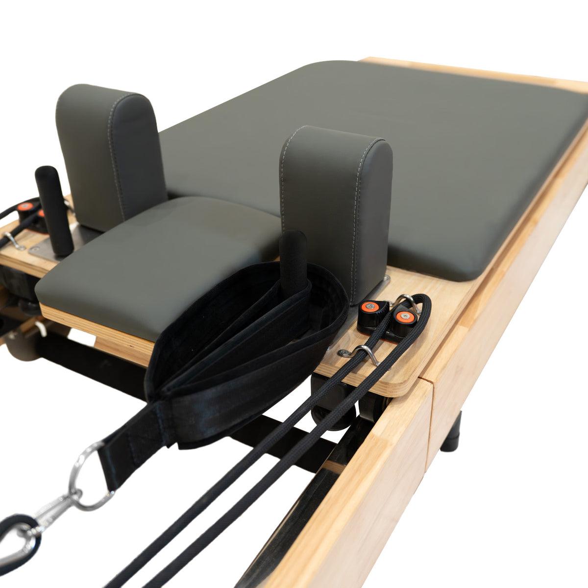 Pilates Reformer Maschine aus Eiche mit grauem Polster, gepolsterten Kopfstützen und verstellbaren Widerstandsbändern für vielseitiges Training