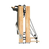 Pilates Reformer Maschine aus Eiche, elegant und stabil, mit glatten Oberflächen, verstellbaren Seilen und einem kompakten, klappbaren Design