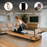 Pilates Reformer Maschine aus Eiche mit klappbarem Design, schwarzem Trampolin-Zubehör und Aufbewahrungshülle, ideal für effektives Training