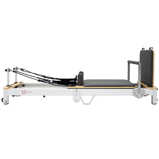 Pilates-Reformer in Weiß mit schwarzem Polster, verstellbaren Riemen und Holzdetails, ideal für effektives Training und Rehabilitation