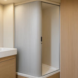 Silberne Rollladen-Duschtür mit vertikalen Rillen, elegant und modern, passt perfekt in ein helles Badezimmer mit Holzdetails