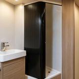 Schwarze Rollladen-Duschtür mit vertikalen Rillen, elegant und modern, passt perfekt in ein Badezimmer mit Holz- und weißen Akzenten