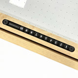 Holzspielzeug mit nummerierten Holzscheiben in Schwarz, eingebaut in einen hellen Eichenrahmen, ideal für kreative Spiele und Lernaktivitäten