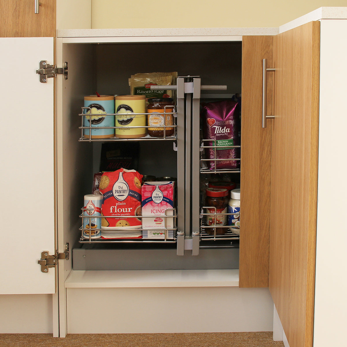 Der KuKoo Magic Corner Eckschrank in Holzoptik mit zwei ausziehbaren Regalen, gefüllt mit Lebensmitteln und Vorräten, öffnet rechts