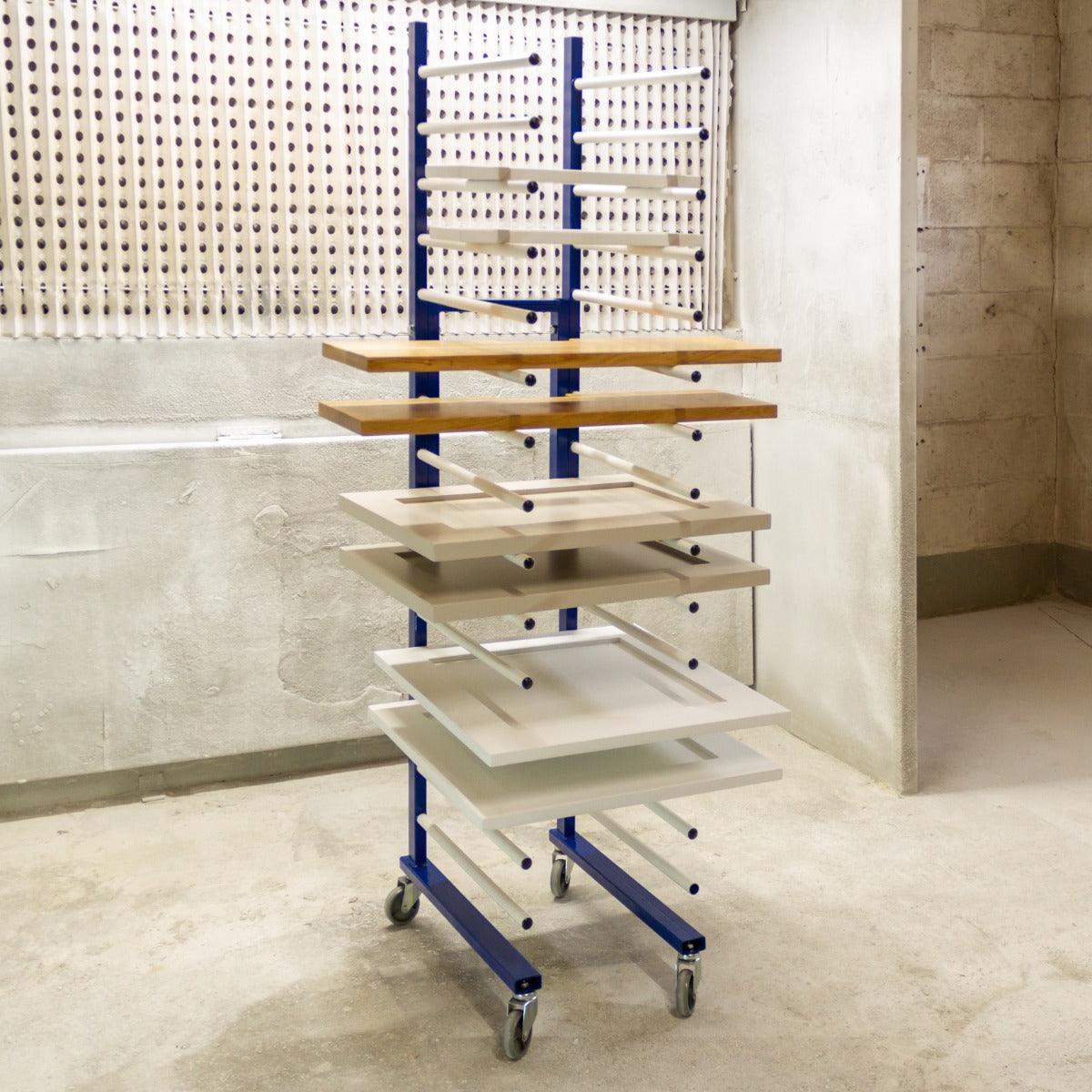 Trocknungswagen mit blauer Metallstruktur und mehreren Regalen in verschiedenen Farben, ideal zum Trocknen von Materialien in Werkstätten