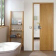 Schiebetürsystem in warmem Holzton, elegant in einem modernen Raum mit Badewanne und Regalen, die dekorative Objekte und Handtücher zeigen